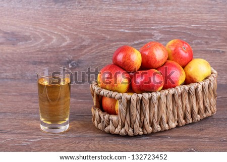 apples in a basket with apple juice on a wooden background