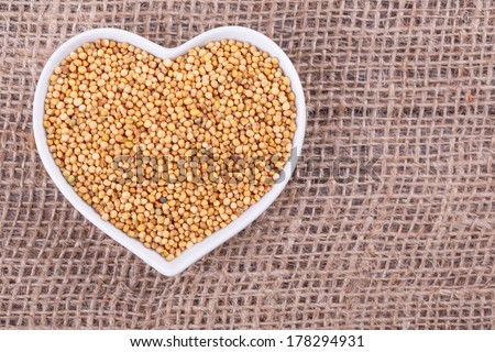 mustard seed in  cup in the shape of heart on sack  cloth