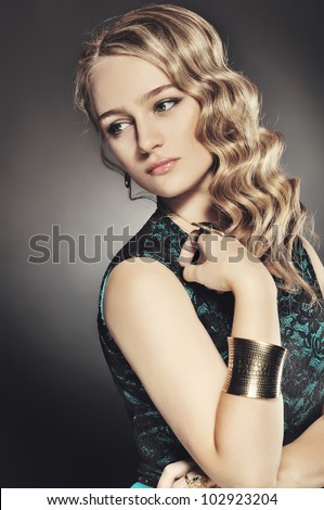 very beautiful and attractive young blond lady in elegant silk dress and with old fashion hair style
