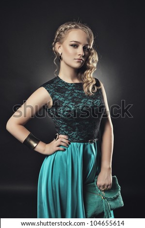 very beautiful and attractive young blond lady in elegant silk dress and with old fashion hair style