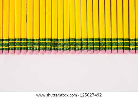 A bunch of number 2 pencil erasers, laid out in a row, on a white background.