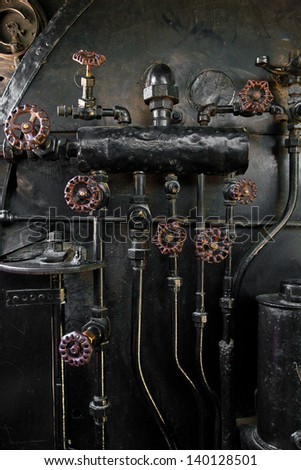 A Series Of Pipes And Knobs On A Steam Engine Boiler.