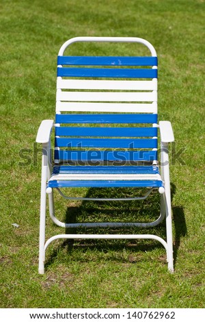 Blue and white lawn chair on grass.