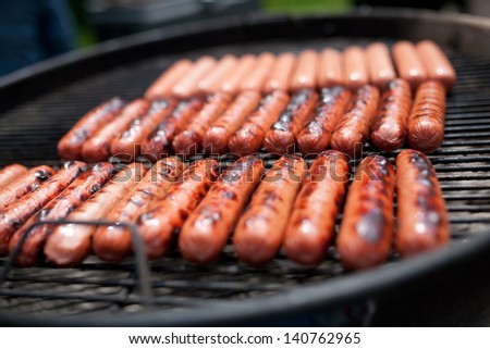 Several Cooking Hot Dogs On A Grill