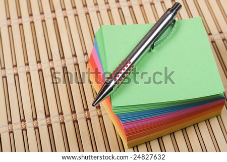 Colored notes block with a pen on the top of it