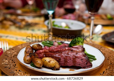 Roast beef with gravy and roasted potatoes side and green vegetables