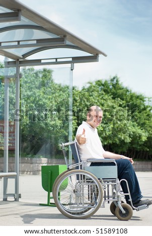 Man in a wheelchair at a bus stop