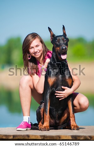 Young beautiful girl with a dog near lake
