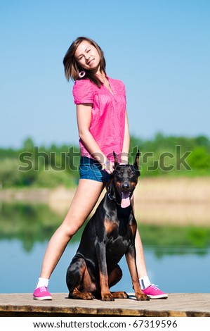Young beautiful girl with a dog near lake