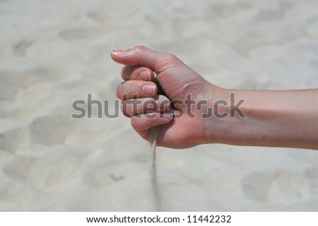 Girl hand with falling sand - metaphor of loosing time