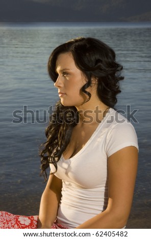 A portrait of a beautiful young girl beside a lake. Plenty of negative space for text in this romantic image.
