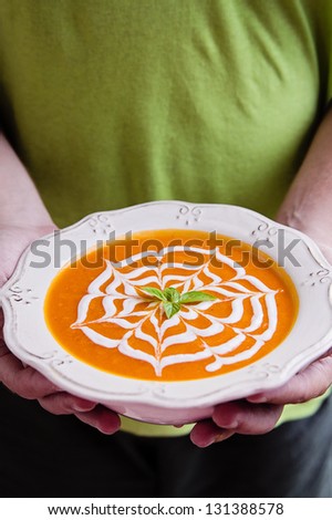 Hands holding a bowl of lentil cream soup