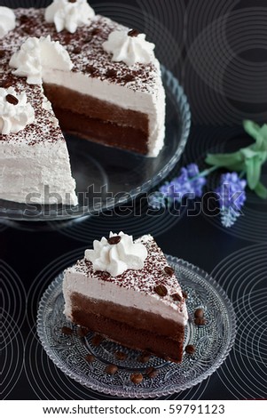 Cake with cocoa and cream with slice on black background