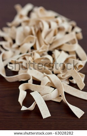 Raw pasta on wooden table