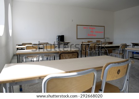A whiteboard in the classroom at school with the messagelet is begin the summer holidays written with red marker on it symbolizing the end of the school  and the start of the summer holidays
