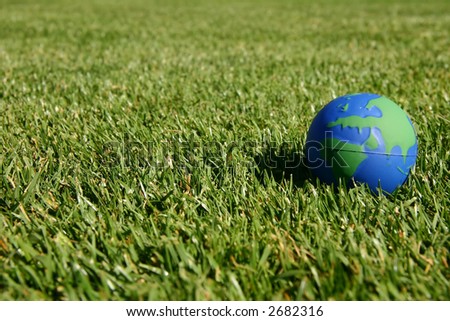 Blue and green earth globe in green grass