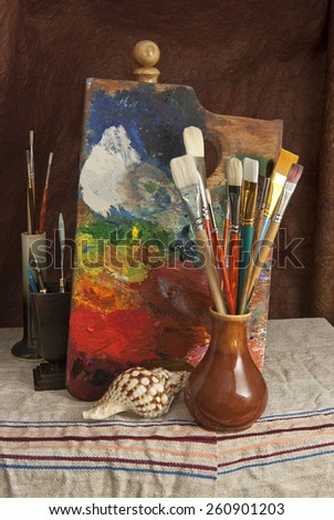 Still life with art materials and tools on a brown background and cloth.