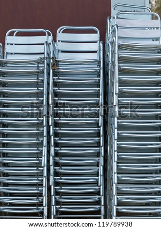 Shiny steel chairs stacked outside a restaurant