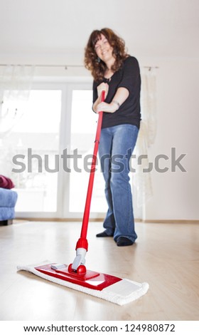 Young woman mopping the floor