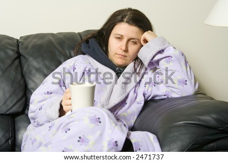 woman with a cold holding a cup with a hot tea