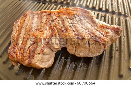 close up photo of a delicious rib eye steak cooking on a grill