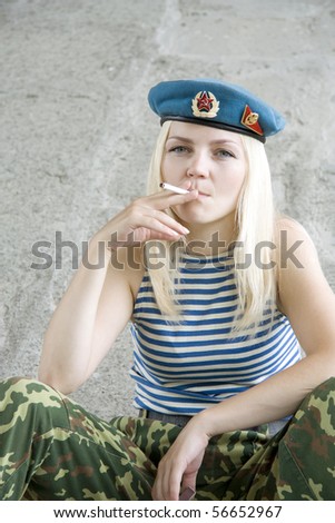 The woman in the military form sits and smokes