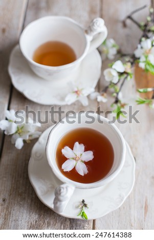 tea cups on wooden table with almond blossom