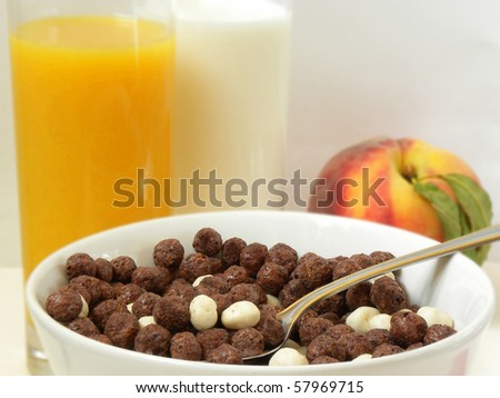 Breakfast. view of the Corn Flakes, chocolate balls, juice and milk,peach