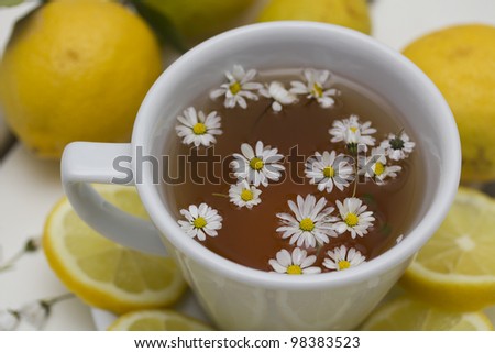 herbal tea with chamomile and lemon on a wooden table