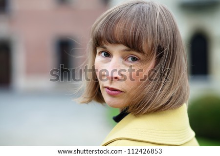 Horizontal outdoor portrait of a middle aged woman turning back