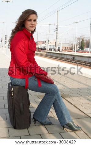 Young brunette woman waiting for a train on a railway station