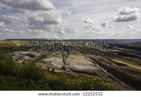 Open-pit mining for lignite (brown coal) that is burnt and transformed to electricity by the power station at the horizon - largest mining sites and power production site in Germany