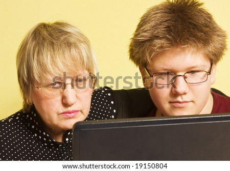 grandmother with her grandson looking at the screen of  laptop computer