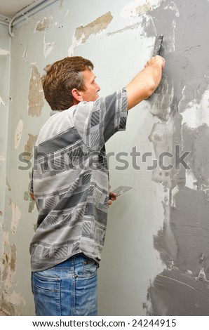 Plasterer at work doing indoor house repair with plaster