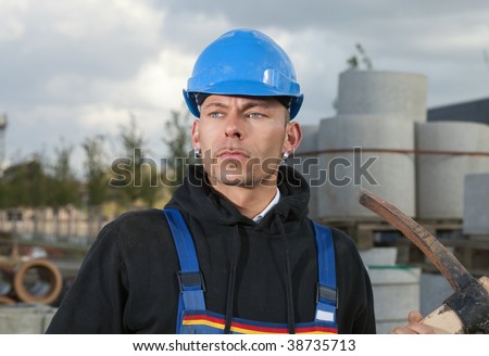 Construction worker in blue hard hat standing outdoors at construction site