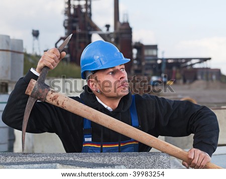Worker in blue hard hat standing against industrial background