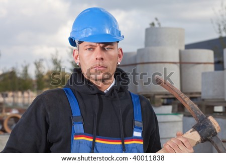 Construction worker in blue hard hat standing outdoors at construction site