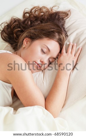 Pretty young woman sleeps in her bed