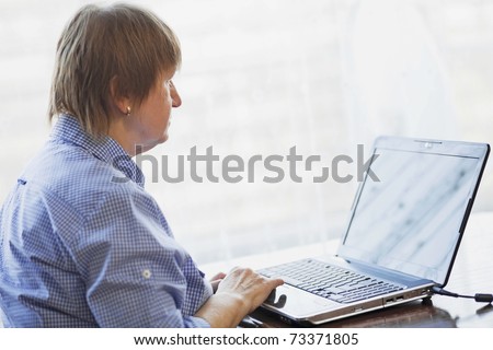 Elder woman working with laptop computer at home