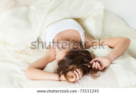 Pretty young woman sleeps in her bed