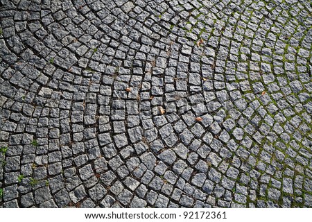 Closeup view on a cobblestone road - pattern - background - contrasty due to a side sunlight