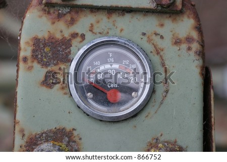 Old temperature gauge on a derelict piece of farm machinery.  Has C and F markings.