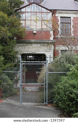 Old university laboratory entrance, built in 1929.  Currently disused due to earthquake risk. Security fence to keep people out.