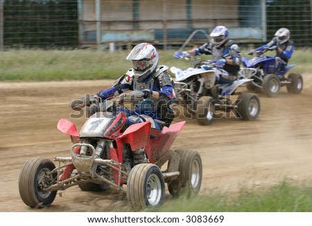 ATV Flat track racing action from New Zealand.  Three riders powering round a bend.  (logos removed)