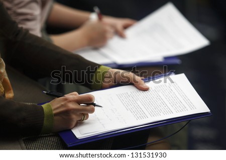 Journalist is reading press material during a conference