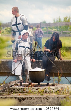 KALININGRAD, RUSSIA - JUNE 17: men in suit of Teutonic knight cooks food on knightly tournament \