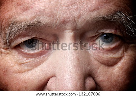 old man face part closeup eyes looks at camera