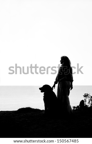 bernese mountain dog and woman silhouettes  looks aside at sea