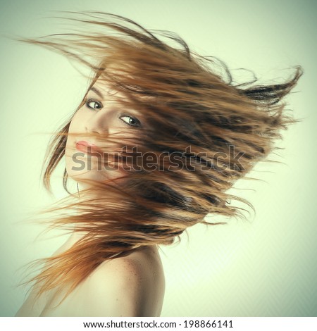 Young Woman\'s Long Hair Flying in Motion Blur effect toned image