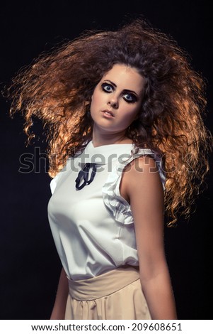 pensive crazy woman with fluffy hair looking at camera. Toned image
